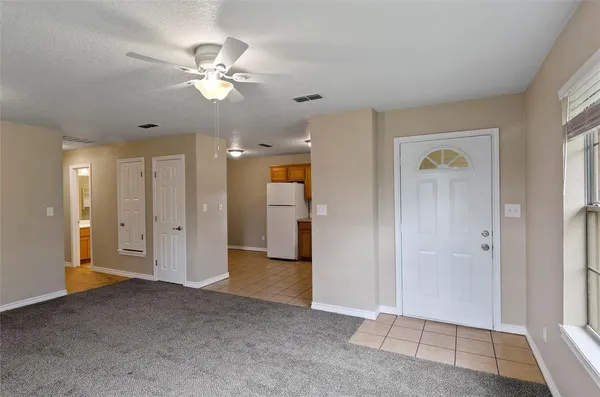 a view of a livingroom with a chandelier fan and windows