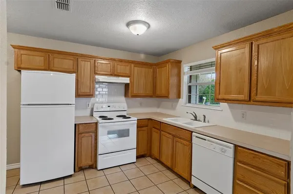 a kitchen with a stove sink and cabinets