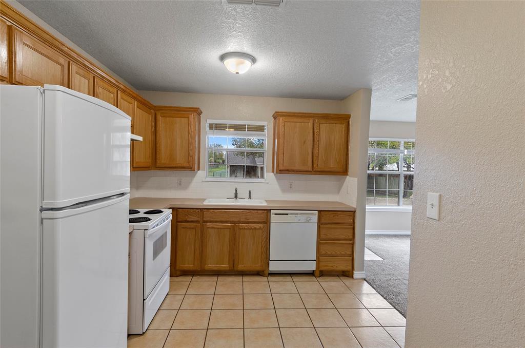 225 Oak Court, Unit 225 Rhome, TX 76078 - Photo 9 of 30 a kitchen with stainless steel appliances a refrigerator sink and cabinets