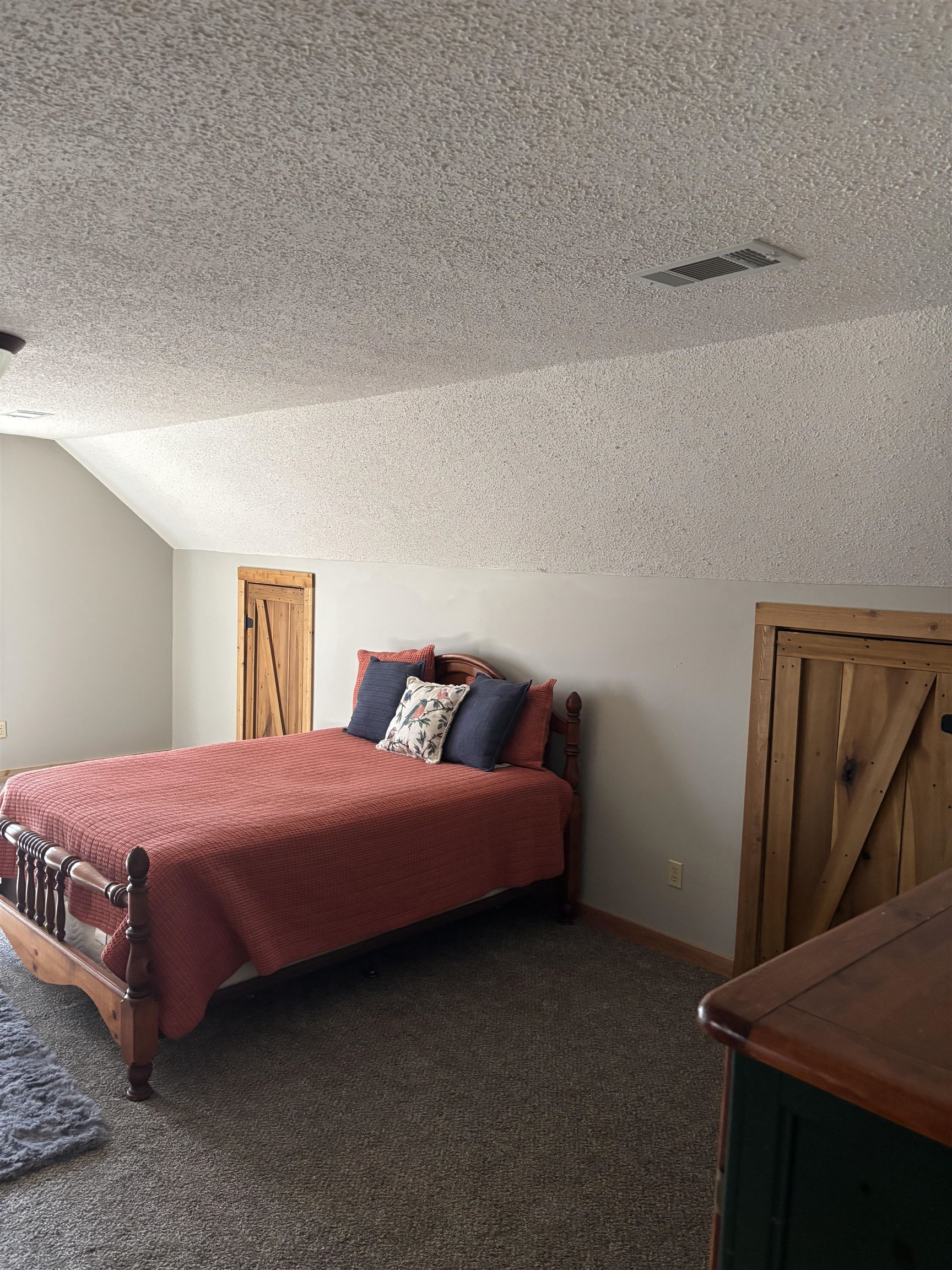 7462 Campground Road Drummonds, TN 38023 - Photo 23 of 31 Sloped ceiling featuring a textured finish, wood-look barn doors, and soft gray carpeting