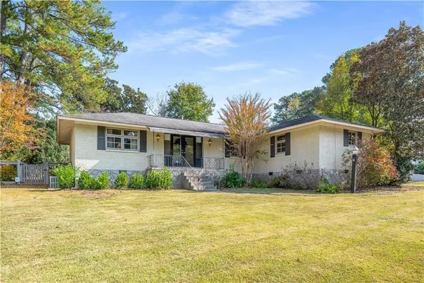 a front view of house with yard and trees around