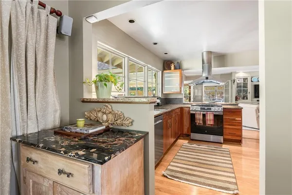 a kitchen with stainless steel appliances granite countertop a stove a sink and a refrigerator