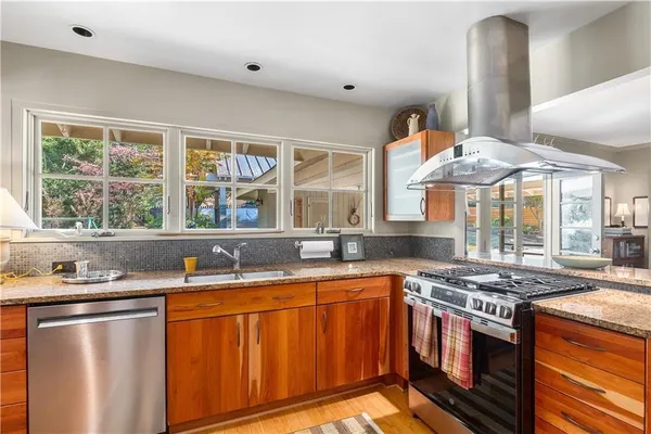 a kitchen with stainless steel appliances granite countertop a sink stove and refrigerator