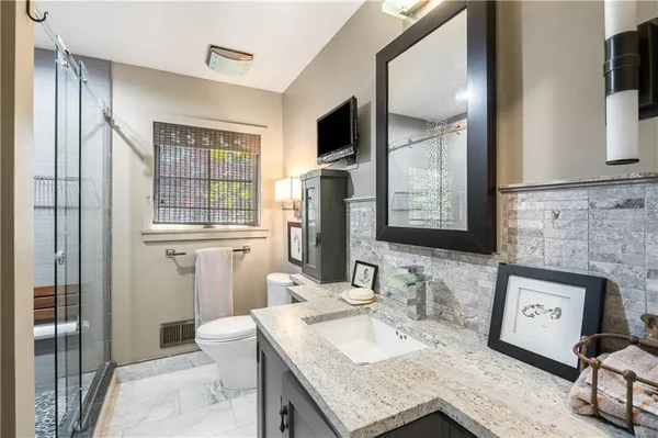 a en suite bathroom with a granite countertop double vanity sink and a mirror