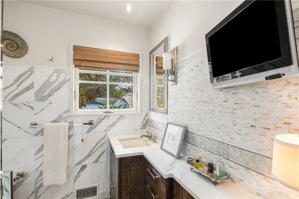 a bathroom with a sink a large mirror and a bathtub