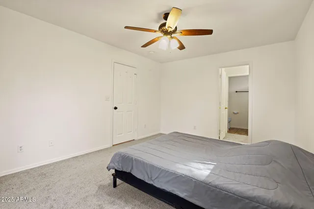 a bedroom with a bed and a ceiling fan