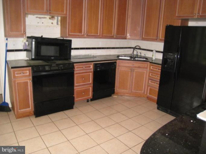5305 Falls Rd Terrace Baltimore, MD 21210 - Photo 4 of 20 a kitchen with granite countertop a stove and a refrigerator