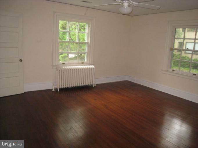 5305 Falls Rd Terrace Baltimore, MD 21210 - Photo 8 of 20 an empty room with wooden floor and windows