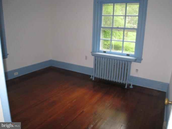 5305 Falls Rd Terrace Baltimore, MD 21210 - Photo 10 of 20 an empty room with wooden floor and windows