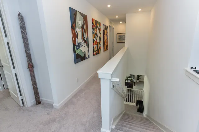 a view of hallway with stairs and wooden floor