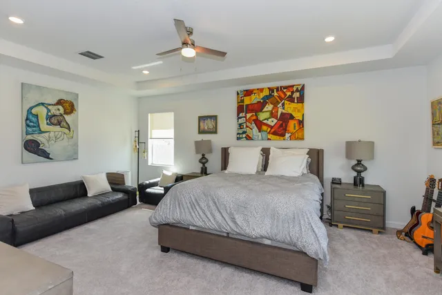 a bedroom with a bed and painting on the wall