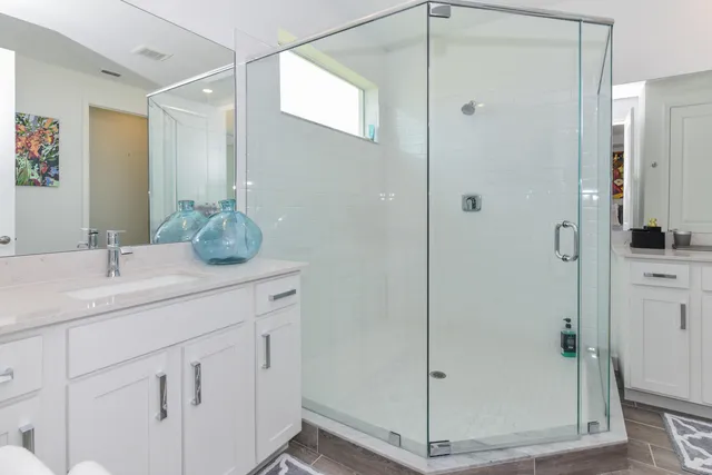 a bathroom with a shower sink and mirror