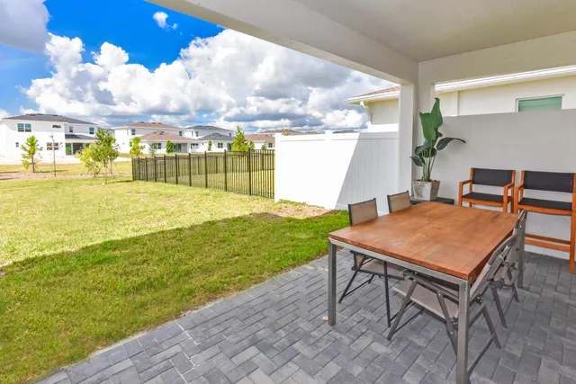 a backyard of a house with table and chairs