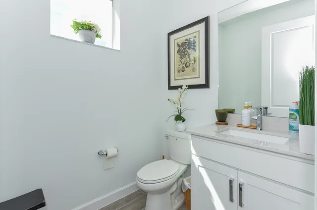 a bathroom with a granite countertop toilet sink and mirror