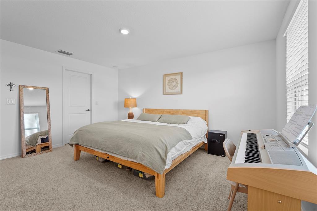 8564 Lunar Skye Street Sarasota, FL 34241 - Photo 21 of 44 a bedroom with a bed and a table in it