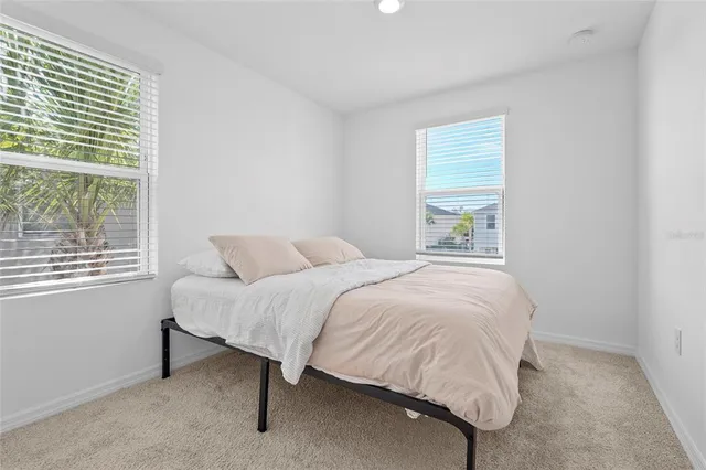 a bedroom with a bed lamp and a window