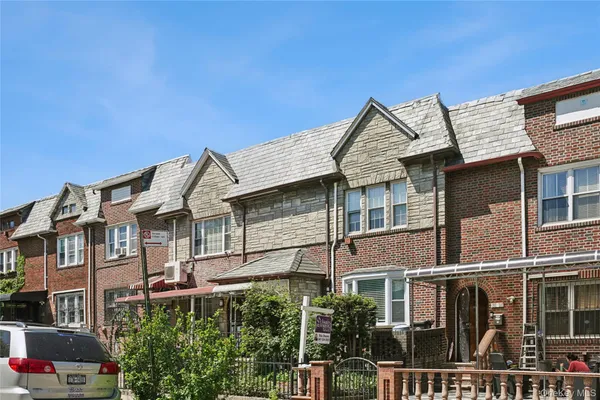 a front view of a residential apartment building with a yard