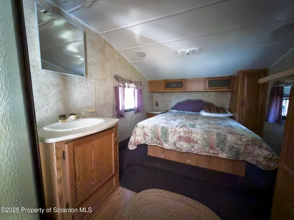 a view of hallway with wooden floor and flat screen tv