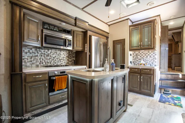a kitchen with stainless steel appliances granite countertop a sink a stove and a refrigerator