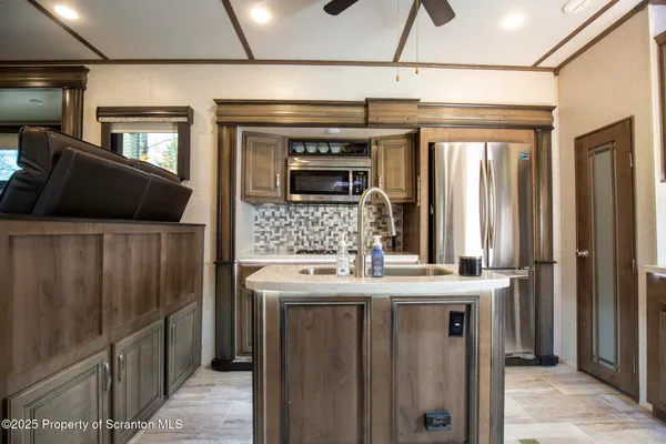 a kitchen with stainless steel appliances granite countertop a refrigerator and a sink