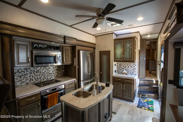 a kitchen with stainless steel appliances granite countertop a refrigerator and a stove top oven