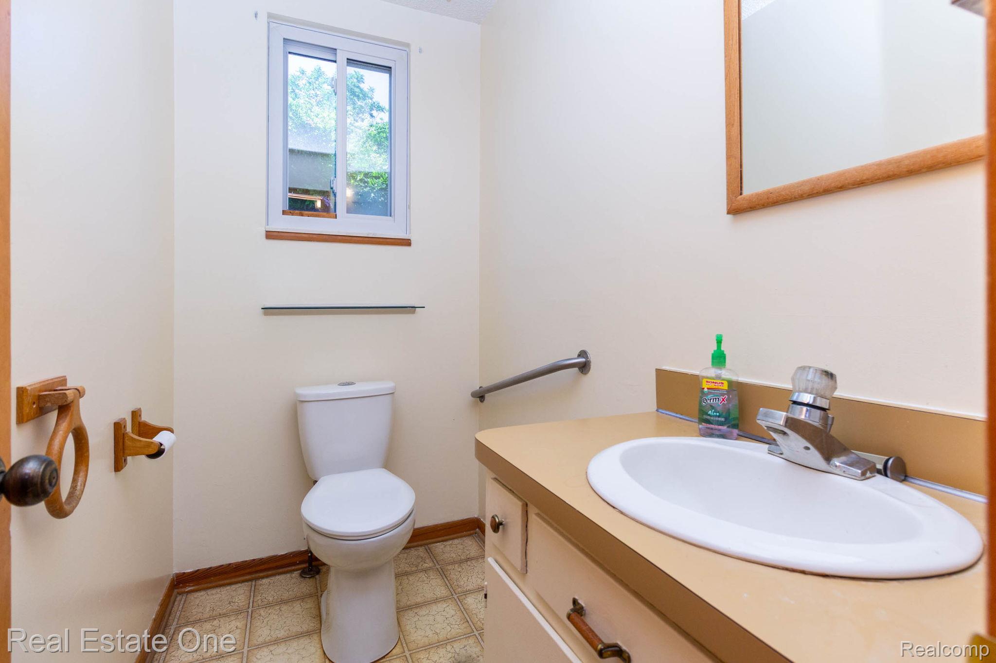 13912 Clinton River Road Sterling Heights, MI 48313 - Photo 22 of 43 Bathroom featuring a vanity with an integrated sink, a mirrored medicine cabinet, and a window with a wood sill