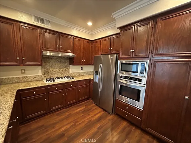an empty room with wooden floor and a ceiling fan