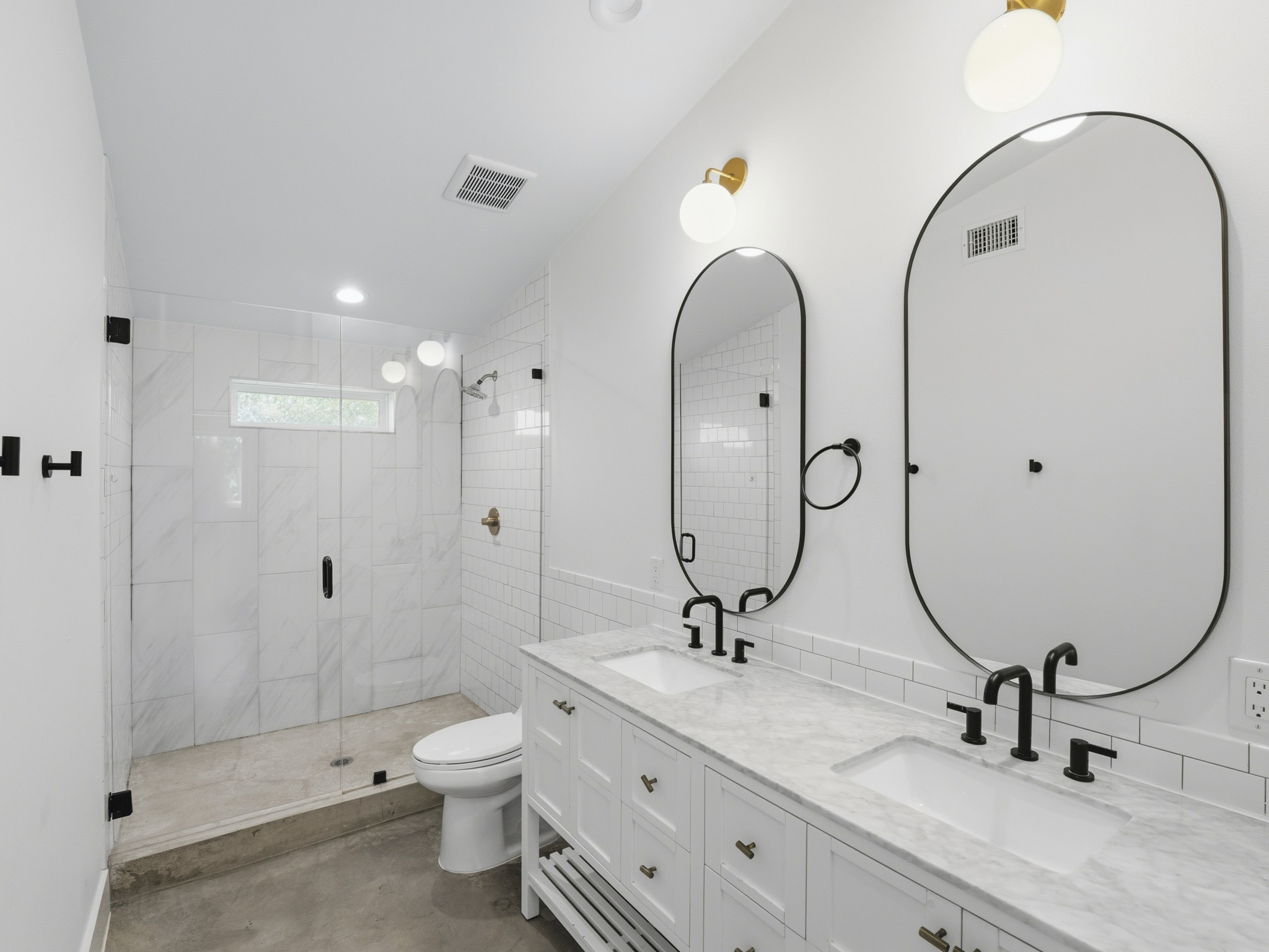 5005 Lott Avenue, Unit 2 Austin, TX 78721 - Photo 14 of 25 Dual vanity with sleek fixtures anchors this pristine primary bathroom, offering a serene escape.