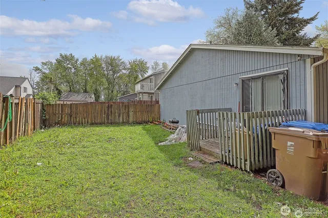 a view of a house with a yard and wooden fence
