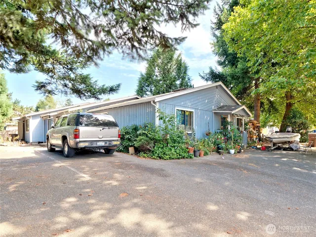 a view of a house with a garden and parking space