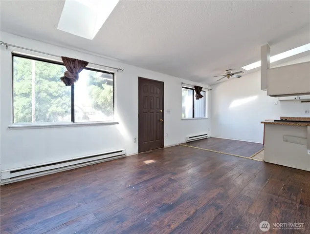 an empty room with wooden floor and windows