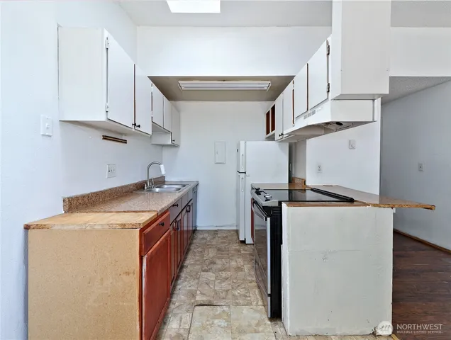 a kitchen with stainless steel appliances granite countertop a refrigerator a stove and a sink