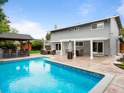 a view of a house with swimming pool and sitting area