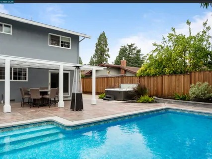 a swimming pool with outdoor seating and yard