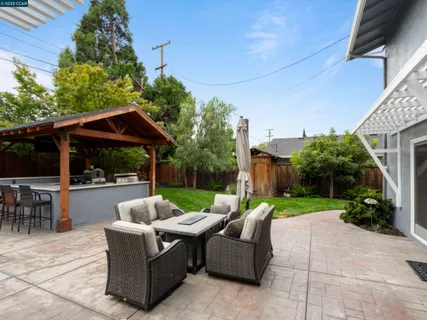 a view of a patio with couches and table and chairs under an umbrella