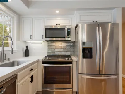 a kitchen with refrigerator a microwave and cabinets