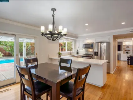 a view of a dining room with furniture wooden floor and chandelier