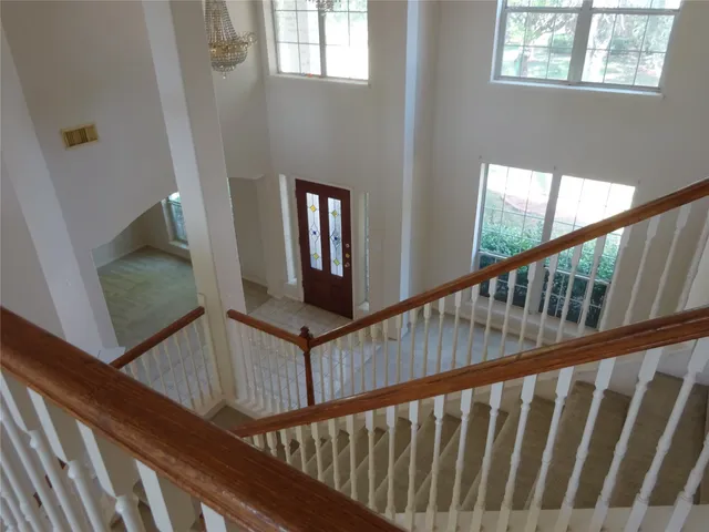 a view of staircase with lots of frames on wall and a window