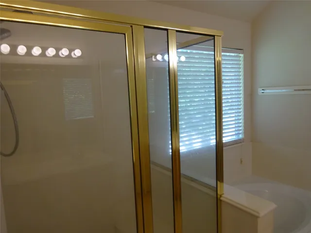 a bathroom with a glass shower door and a bathtub