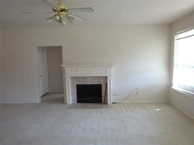 an empty room with windows and fireplace