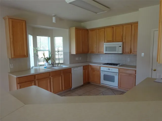 a kitchen with stainless steel appliances granite countertop a stove a sink dishwasher a refrigerator and a microwave oven