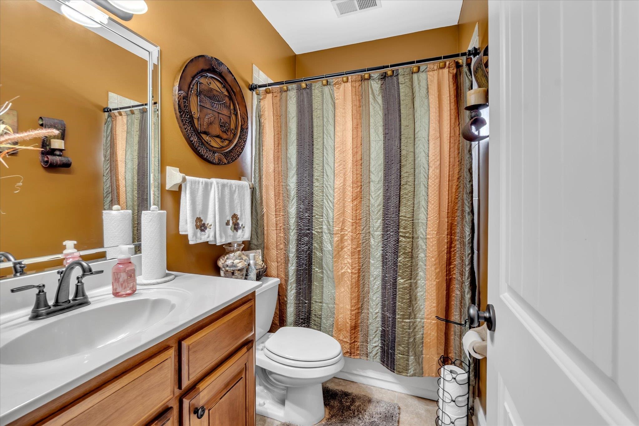 7284 Bucknell Road Millington, TN 38053 - Photo 17 of 35 Vanity with wood-finish cabinetry, white countertop, and dark-finish faucet