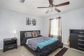 10763 Sandpiper Drive Houston, TX 77096 - Photo 21 of 26 a bedroom with a bed and a chandelier