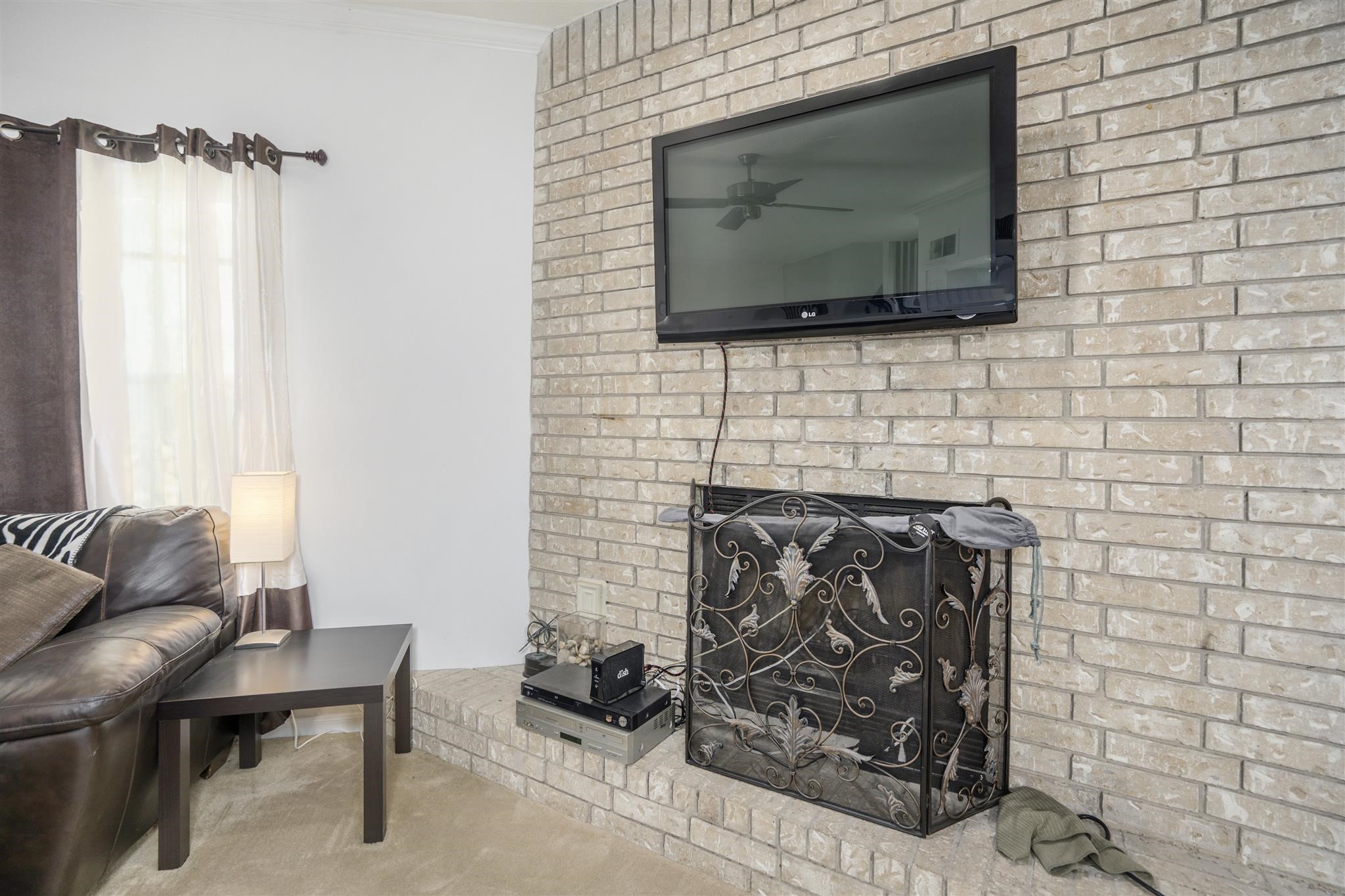 10763 Sandpiper Drive Houston, TX 77096 - Photo 9 of 26 a living room with fireplace furniture and a flat screen tv