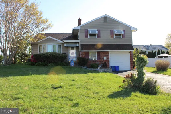 a front view of a house with yard and green space