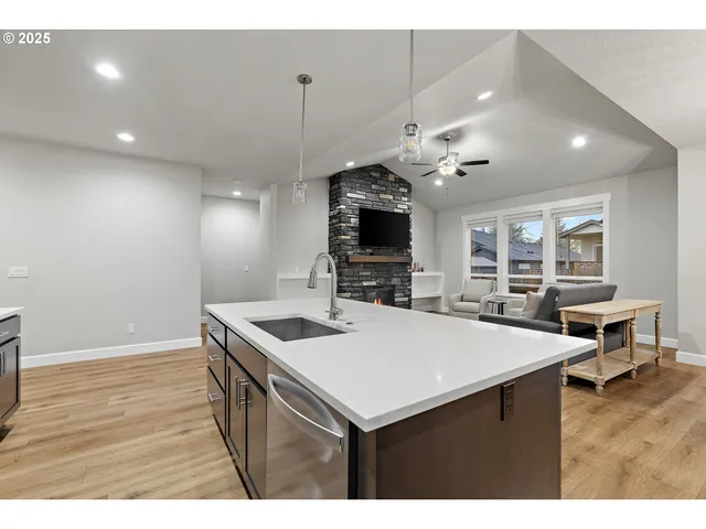 a kitchen with a sink a counter top space and stainless steel appliances