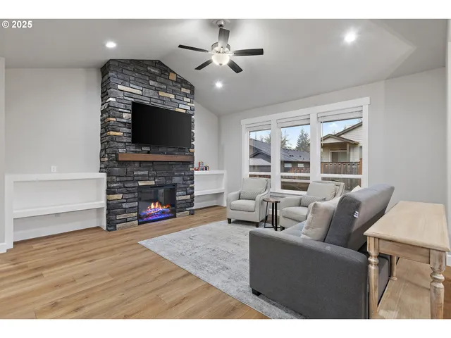 a living room with furniture a fireplace and a flat screen tv