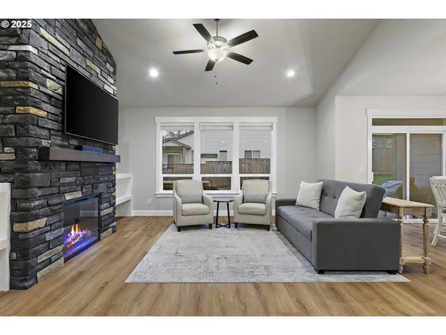 a living room with furniture a flat screen tv and a fireplace