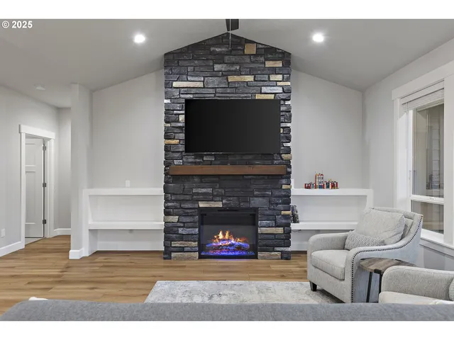 a living room with furniture a flat screen tv and a fireplace