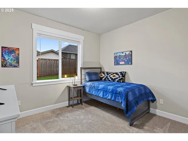 a bedroom with a bed and a painting on the wall